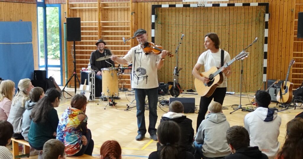 Das dänische Folk-Rock Trio 'TUMULT' bei einem ihrer Schulkonzerte © Verein Miteinander leben e.V.